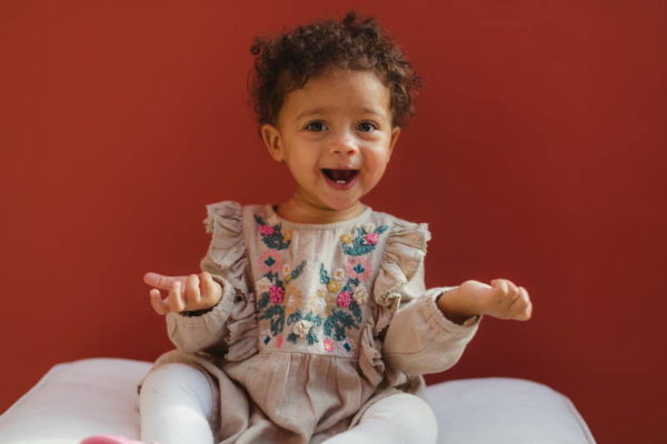 Musikgarten für Babys in Fürth - ein lachendes Mädchen mit dunkler Haut und süßen Locken